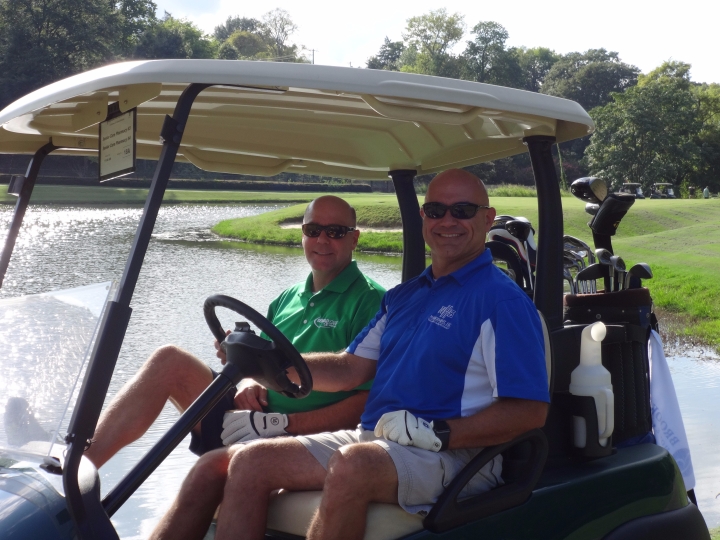 Two golfers sitting in a golf cart