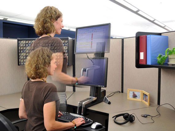 A picture of a computer rising and falling with a woman as she sits and stands